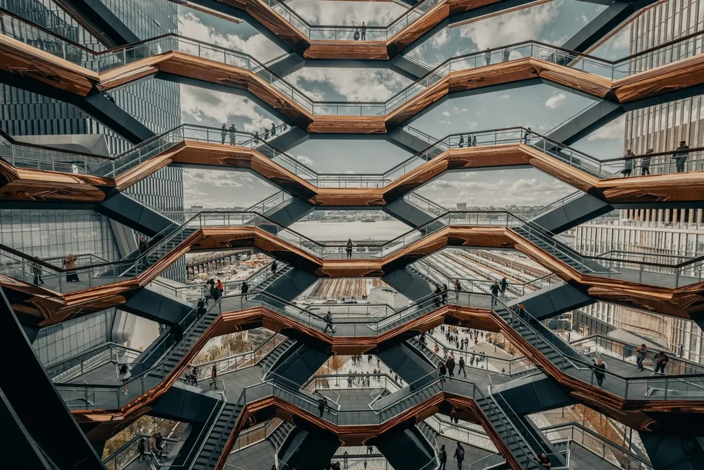Interlocking flights of stairs and landings seen from above, with people spread across the levels