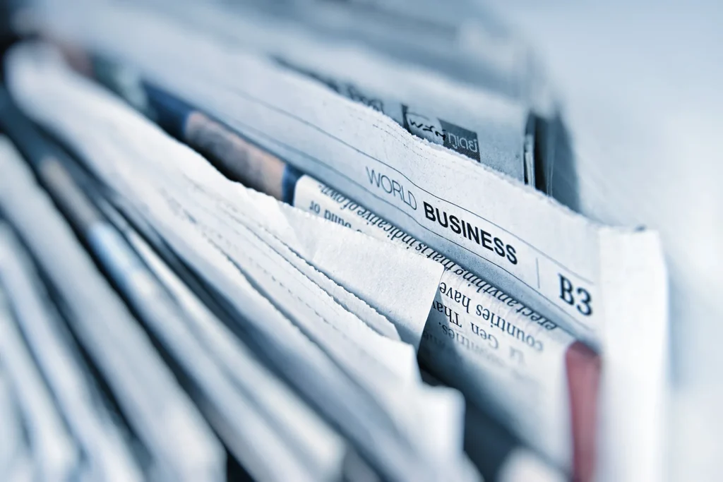 A stack of folded newspapers, the world business section uppermost