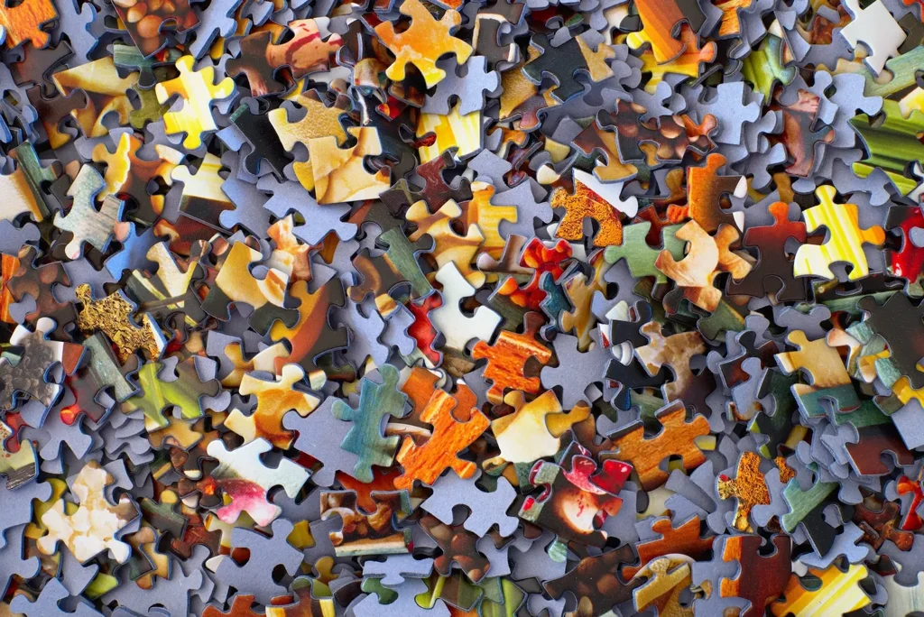 Hundreds of unsorted jigsaw pieces face up, none of them joined
