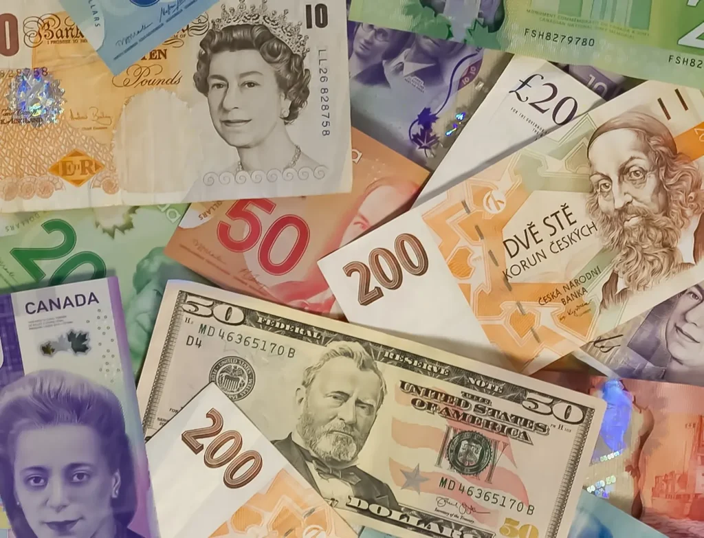 Banknotes from several countries overlapping, sterling and US dollars uppermost