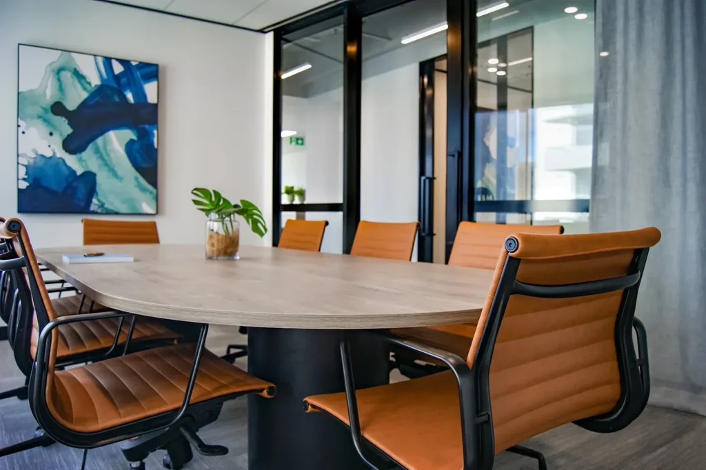 Empty boardroom with an oval table and tan leather chairs