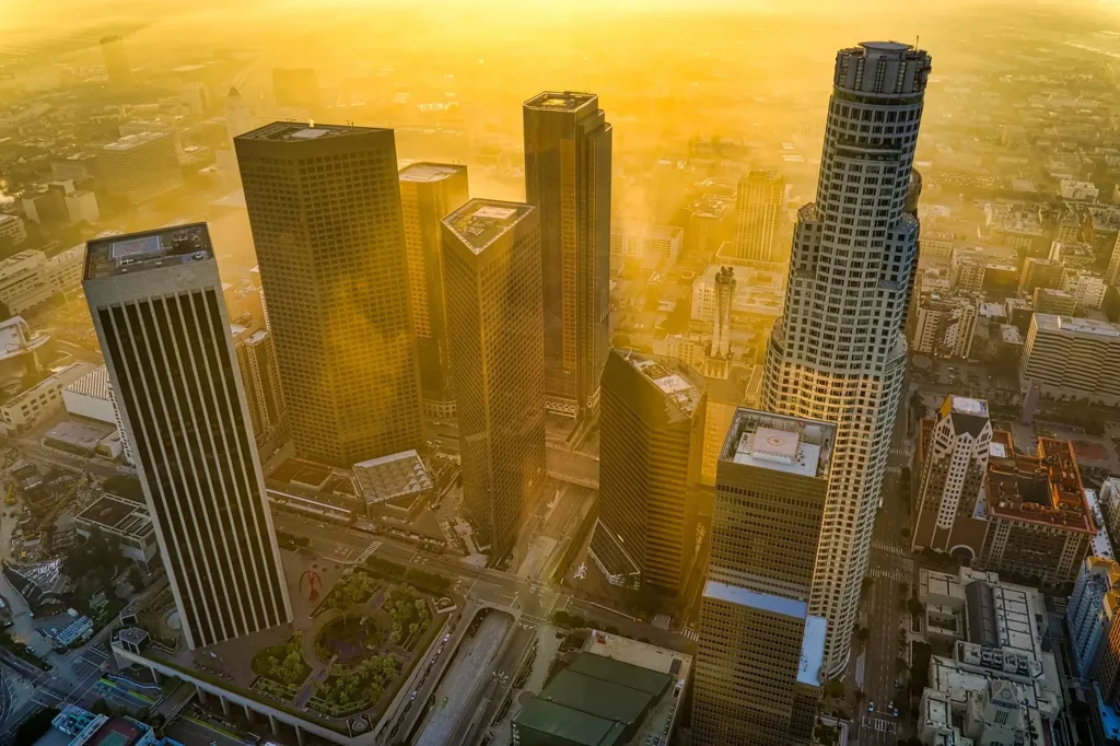 Downtown office towers seen from above through heavy golden haze